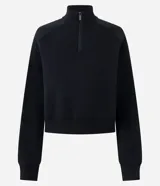 Buzo de algodón con felpa, de corte estructurado y diseño cropped. Presenta cuello alto con medio cierre frontal, mangas largas con puños elásticos y ruedo con elástico ancho.