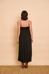 Vestido largo negro con tirantes finos, escote en V y el busto bordado con lentejuelas. Presenta líneas de bordados verticales a lo largo de la falda fluida.