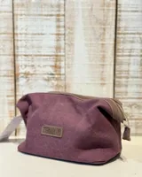 Neceser de tela color borgoña con detalles en cuero marrón y cierre superior con cremallera.