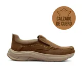 Zapato casual tipo slip-on de cuero color marrón, con costuras decorativas a la vista y suela de goma ergonómica en tono beige.