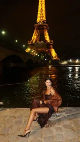 Vestido midi de satén color marrón con estampado a cuadros, escote drapeado y tirantes finos. Presenta un tajo lateral profundo en la falda.