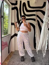 Pantalón palazzo de tiro alto, holgado, con estampado de hojas en tonos celeste claro y beige. Posee elástico en la cintura y lazos ajustables en los tobillos.