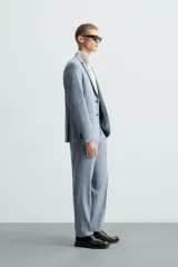 Blazer de corte slim fit confeccionada en tejido con lana, con cuello de solapas de muesca, cierre frontal de un botón, bolsillos laterales con solapa y bolsillo de vivo en el pecho.