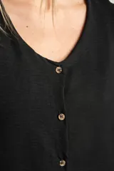 Blusa negra de manga corta con volados en los hombros, escote en V y cierre frontal con botones pequeños.