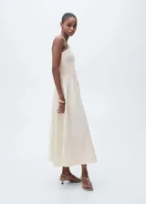 Vestido midi de diseño combinado con cuello halter y tirantes finos. Presenta un cuerpo superior de tejido texturizado con panel fruncido y una falda evasé de caída fluida. Incluye cierre de cremallera lateral.