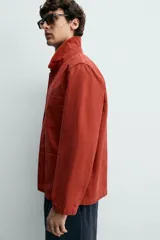 Sobrecamisa de algodón color rojo con efecto lavado, corte regular fit, cuello solapa, cierre frontal de botones, bolsillo en el pecho y bolsillos frontales de plastrón.