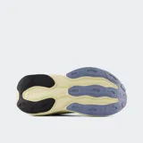 Championes de running New Balance modelo Fresh Foam More V5, color gris con detalles en lila y amarillo pálido. Presentan una entresuela Fresh Foam X sobredimensionada para máxima amortiguación, capellada de malla transpirable y ajuste mediante cordones.