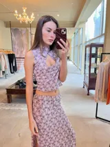 Top corto lila con estampado floral, cuello mao con abertura en forma de gota y cierre con botón invisible. Confeccionado en lycra.