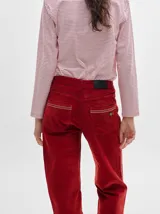 Pantalón de tiro medio confeccionado en pana color rojo, con corte holgado y detalle de línea lateral en contraste.