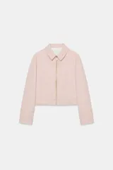 Chaqueta rosa de cuello solapa y manga larga, con cierre frontal y detalles de cremallera metálica.