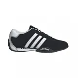 Championes Adidas modelo Adi Racer Lo, de diseño inspirado en el automovilismo. Presentan una base de gamuza negra con las icónicas tres tiras laterales en color plateado y detalles metálicos en el talón. Incluyen suela de goma con logo Adidas en el lateral.