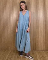 Vestido largo de denim celeste, sin mangas, con escote en V, corte amplio, bolsillos laterales y tajos pronunciados en la parte inferior con detalles de pespuntes.