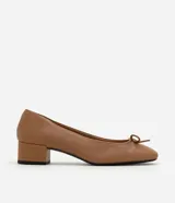 Zapato femenino de cuero color tostado, estilo muñeca con punta redondeada y detalle de mini lazo en la parte superior. Cuenta con tacón bloque de altura mediana.
