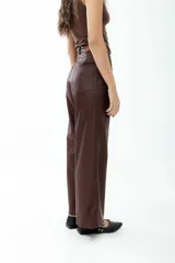 Pantalón de cuero color chocolate, de tiro medio-alto y corte recto.