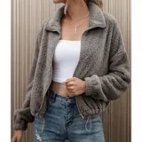 Campera corta de textura peluda tipo polar, color gris, con cierre frontal, cuello alto y elástico ajustable en la cintura.