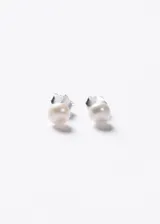 Par de aros tipo broquel con perla de río natural de 4mm de diámetro, montadas sobre base de plata 925.