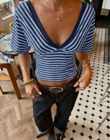 Top de manga corta con escote cruzado en V, diseño ajustado al cuerpo y estampa de rayas horizontales en tonos azules y oscuros.