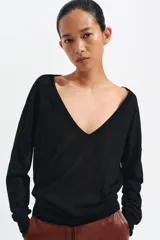 Jersey de punto fino negro con escote en V profundo y manga larga con puños ajustados.