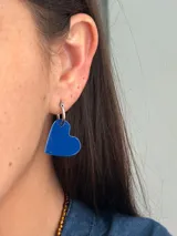 Aro tipo argolla de acero quirúrgico con dije colgante en forma de corazón de color azul, pintado a mano.