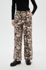 Pantalon de corte baggy con cintura media y bolsillos laterales. Presenta un estampado abstracto tipo camuflado en tonos tierra.