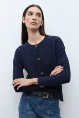 Cardigan de punto con textura de tejido estructurado, color bordó, con cuello redondo, cierre frontal de botones y mangas largas.