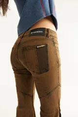 Jean estilo oxford tiro medio, color negro, con recortes curvos y botones en la botamanga. Confeccionado en denim super elastizado.