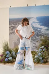 Pantalon largo de corte amplio y fluido, con estampado artístico que simula un paisaje marino en tonos celestes, azules y arena.