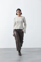 Pantalón de corte recto y pierna amplia confeccionado en símil cuero color marrón oscuro. Presenta una silueta estructurada con costuras verticales frontales que definen su diseño.