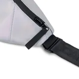 Riñonera reversible Cabaia, con un lado liso plateado iridiscente y un lado estampado. Tiene un compartimento principal con cierre y un bolsillo lateral pequeño. Se puede usar en la cintura o al hombro.