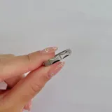 Anillo plateado de acero con forma irregular y bordes texturizados.