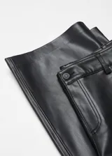 Pantalón de tiro alto con efecto piel, de diseño recto y largo. Cuenta con trabillas para cinturón, cinco bolsillos funcionales y cierre frontal con cremallera y botón.