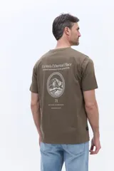 Remera de manga corta color verde oliva, con cuello redondo y calce regular. Presenta un pequeño estampado tipográfico en el pecho con la frase 'Ethereal mountains'.