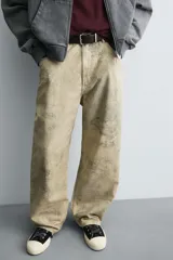 Pantalón de corte baggy fit confeccionado en tejido de algodón con textura y efecto lavado. Presenta diseño de cinco bolsillos, cierre frontal con cremallera y botón.