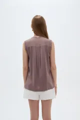 Blusa evasé de viscosa color blanco, sin mangas, con cuello a la base y escote en V con cartera frontal.