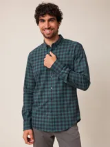 Camisa de manga larga con estampado de cuadros vichy en tonos verde y azul marino. Presenta cuello abotonado, cierre frontal con botones y puños ajustables.