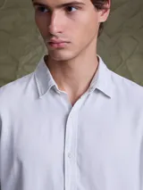 Camisa de manga larga color azul marino, con cuello clásico y cierre frontal de botones.