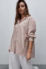 Camisa de manga larga con diseño de rayas verticales blancas y verdes, calce relajado, cuello clásico y botonadura frontal con botones perlados.