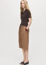 Short estilo jort de tiro medio, confeccionado en tejido de algodón. Presenta diseño recto con pinzas frontales, cierre de botón y cremallera, bolsillos laterales y bolsillos de ribete en la parte posterior. Incluye un cinturón ajustable a tono.