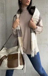 Polera beige de cuello alto y manga larga.