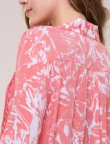 Blusa celeste con estampado efecto pincelada blanca, de corte semi holgado, escote en V con cuello solapa y media abotonadura frontal con botones nacarados. Presenta finas alforzas verticales en la pechera y mangas 3/4 con puños elastizados.