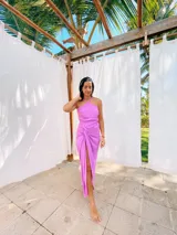 Vestido largo color naranja, con escote halter cruzado y falda tipo pareo con tajo lateral. Confeccionado en tela crepé con caída fluida.