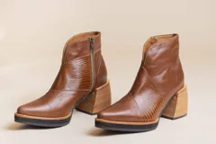 Botas cortas de cuero color marrón con detalle de cuero texturizado en el empeine y cierre lateral.