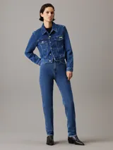 Campera de jean azul índigo, corte cropped, con cuello en punta, bolsillos con solapa en el pecho, botones metálicos y logo de Calvin Klein en el bolsillo del pecho.