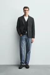 Blazer regular fit de bouclé con diseño pata de gallo en tonos oscuros, solapas de muesca, cierre de un botón y bolsillos con solapa en la cadera.