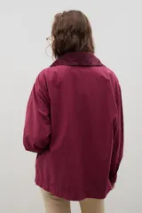 Campera de jean azul oscuro con cuello de pana en color crema. Presenta cierre frontal metálico, bolsillo con cierre en el pecho y bolsillos laterales. Diseño de corte holgado con mangas largas.