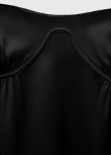 Vestido corto negro con escote tipo corsetero y tirantes finos. Presenta un diseño entallado y cierre lateral invisible.