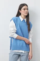 Chaleco tejido de punto con silueta relajada y diseño sin mangas. Presenta lazos laterales ajustables y cuello redondo.