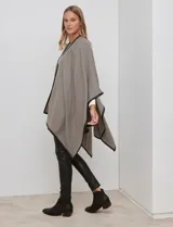 Ruana de tejido suave color azul oscuro, con vivos de ecocuero negro en los bordes.