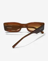 Lentes de sol unisex Hawkers modelo Heaven, con montura rectangular color marrón y lentes degradadas en tonos marrones.