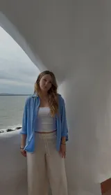 Camisa celeste de crepé, de corte clásico, manga larga y cierre frontal con botones.